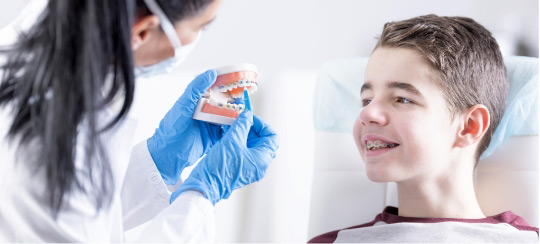 boy-with-braces-next-to-dentist